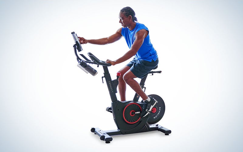 Osoba na kondičním kole Echelon Smart Connect Fitness Bike na prostém pozadí