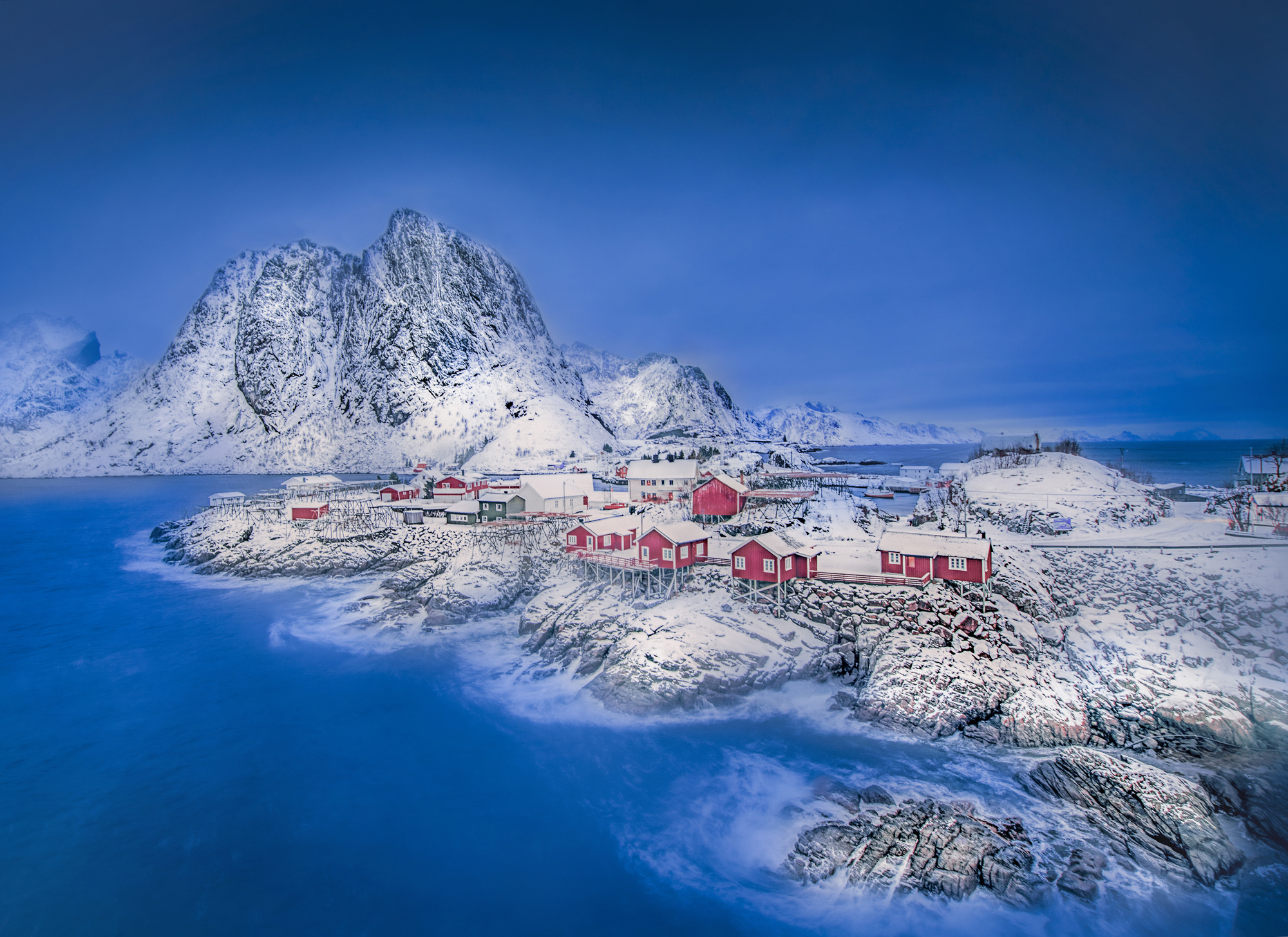 Červené domy tečují fjord pod sněhem
