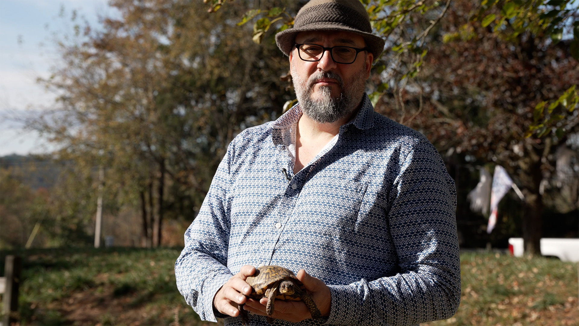 muž drží želvu