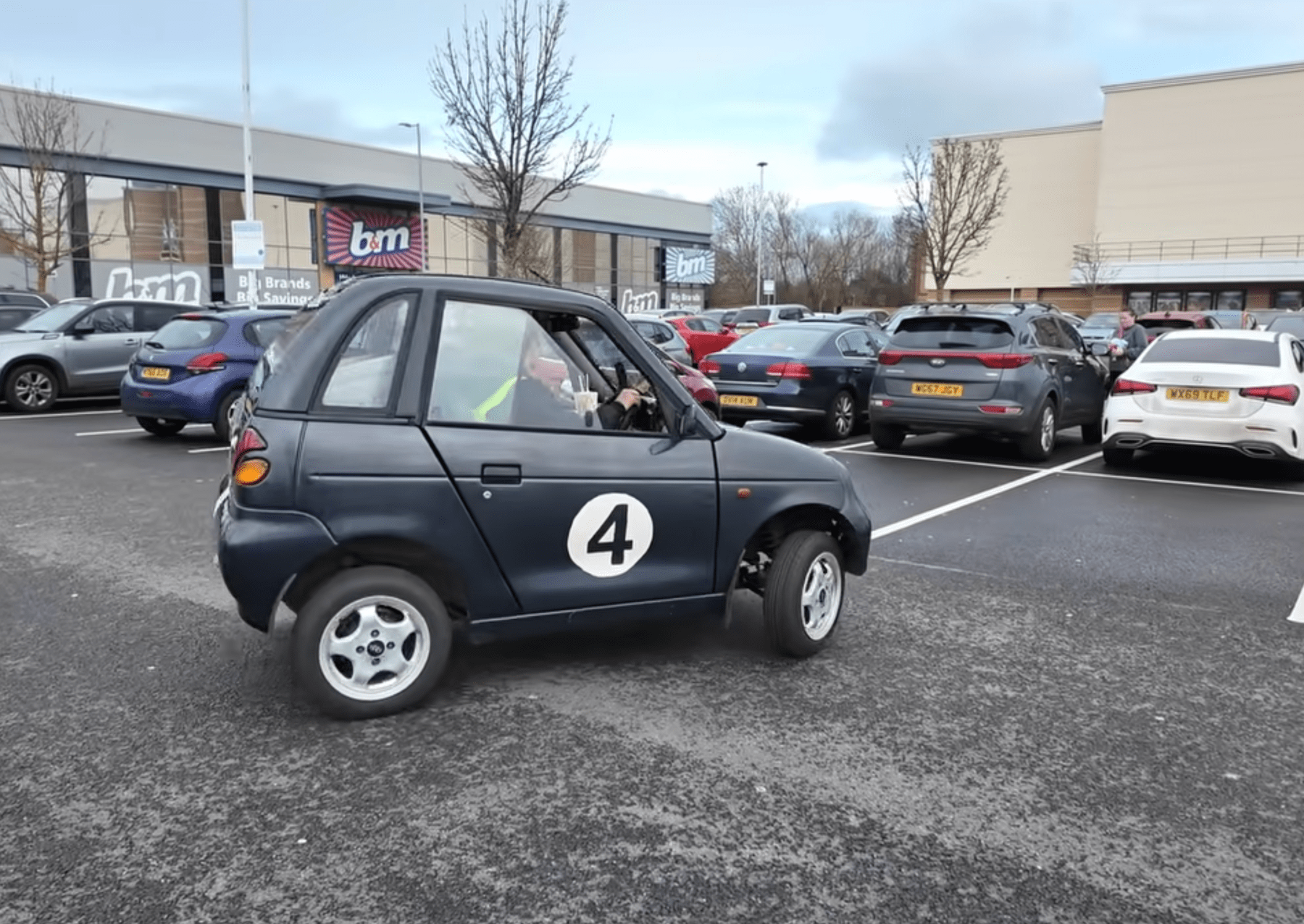 malé černé auto s číslem 4 na parkovišti